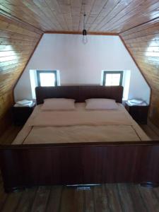 瓦勒博内Bujtina Ahmetaj的木间设有一张大床,设有两个窗户