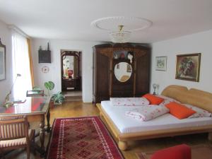 克洛斯特新堡Villa Kreuthhof Appartements的一间卧室配有一张床、一张桌子和一面镜子