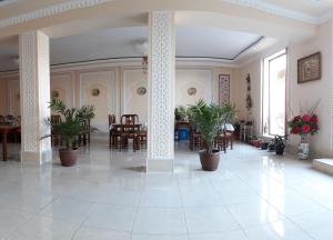 布哈拉Hotel Shams的大房间设有桌椅和盆栽植物