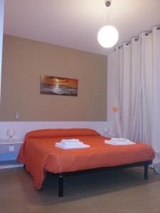圣维托诺曼幸运草住宿加早餐旅馆的一间卧室配有一张带橙色毯子和灯的床。