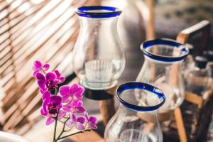 图卢姆阿祖里克度假酒店的四个玻璃花瓶坐在一张紫色花的桌子上