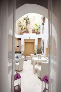 索维拉达玛亚摩洛哥传统庭院住宅的一间客厅,配有白色家具和盆栽植物