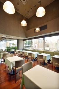 东京新宿普樂美雅凱賓酒店的餐厅设有桌椅和大窗户。