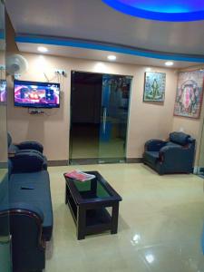 加雅Hotel Sunaina International的客厅配有两张沙发和一台电视机