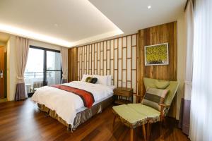 小琉球岛泰美风情旅店的卧室配有床、椅子和窗户。