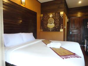 清孔Baanfai Guesthouse Chiangkhong的卧室配有白色的床和木制床头板