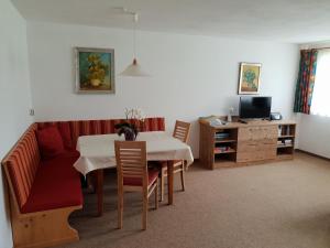 纳瑟尔文勒豪斯比尔格里公寓的客厅配有桌子和红色沙发