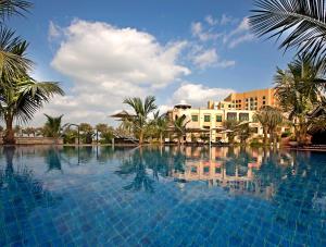阿布扎比Shangri-La Hotel Apartments Qaryat Al Beri的一座棕榈树和建筑的大型游泳池