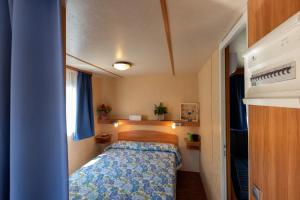 卡瓦利诺卡伯顿村酒店的小房间的小卧室配有床