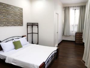 SilayBalay 8 Suites的卧室设有一张白色大床和一扇窗户。