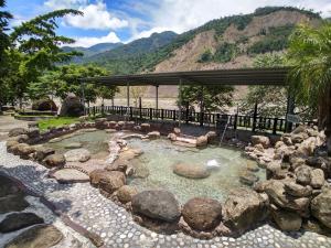 Liugui芳晨温泉渡假村 的一个带岩石和凉亭的水池