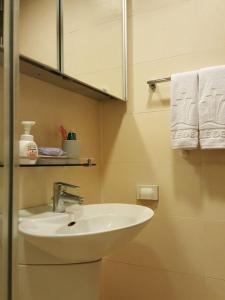 釜山海云台巴达公寓的浴室配有盥洗盆、镜子和毛巾