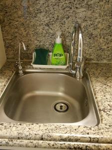 釜山海云台巴达公寓的厨房水槽配有水龙头和绿色洗涤剂