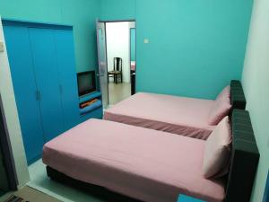 马六甲古城酒店的一间卧室设有两张床、一台电视和蓝色的墙壁