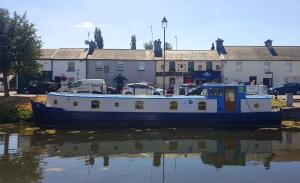 SallinsRoisin Dubh Houseboat的坐在水面上建筑物前的船只