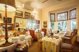 德班戈布尔棕榈宾馆及休闲度假村的用餐室设有桌椅和窗户。
