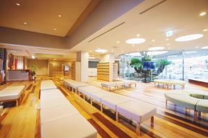 松山高野酒店的一间设有白色椅子和大窗户的等候室