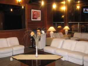 蒙得维的亚欧陆酒店的客厅配有白色的沙发和带鲜花的桌子