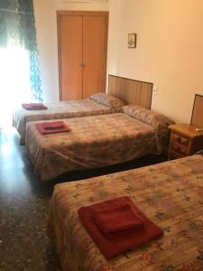 奥罗佩萨德尔马乐斯科拉塔旅舍的一间旅馆房间内的三张床,上面有红色毛巾