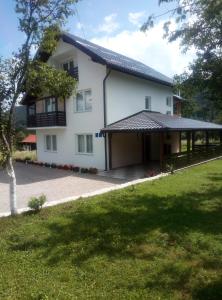 Ličko Petrovo SeloApartments Paradise的一间白色的房子,有黑色的屋顶和院子