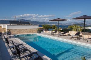 斯拉汀Luxury Poolside Villa的一座大楼内的游泳池,配有椅子和遮阳伞