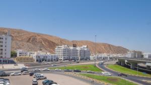 马斯喀特Al Jisr Hotel的城市中繁忙的公路,有建筑物和山