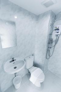 南邦Kanyanat Boutique Hotel的白色的浴室设有卫生间和水槽。