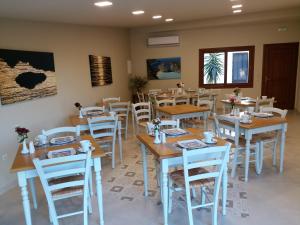 阿普索斯Summer Wine Friendly Resort的用餐室配有木桌和白色椅子