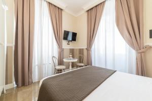罗马罗马齐亚维旅馆的酒店客房,配有一张床和一张桌子及椅子