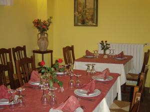 圣阿尔菲奥Ai Vecchi Crateri的用餐室设有2张带红色餐巾和鲜花的桌子