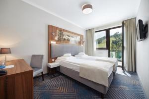 克雷尼察Hotel Pegaz的配有一张床、一张书桌和一扇窗户的酒店客房