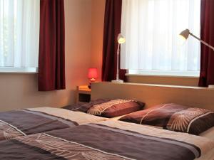 博尔滕哈根Modern Apartment near Sea in Ostseebad Boltenhagen的卧室设有两张床,配有窗户和窗帘