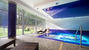 玛丽亚温泉Spa Apartments St. Moritz的一座带大窗户的房屋内的游泳池
