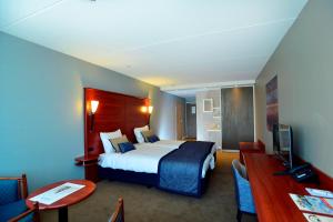 海边的艾格蒙特泽德尔顿酒店的配有一张床和一张书桌的酒店客房