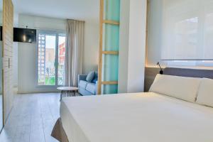 洛斯阿尔卡萨雷斯Apartamentos 525的卧室配有白色的床和蓝色的沙发