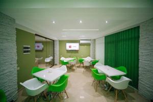 乌雷基Green House的用餐室配有桌子和绿色椅子