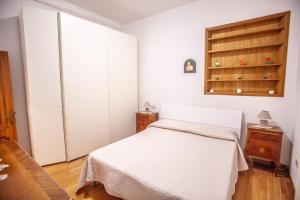 卡斯德尔诺沃贝拉登卡La casa di Francesca的卧室配有白色的床和橱柜。