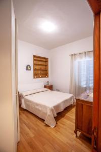 卡斯德尔诺沃贝拉登卡La casa di Francesca的卧室配有白色的床,铺有木地板