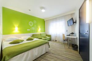 塔林塔林快捷酒店的一间卧室设有一张大床和绿色的墙壁