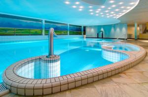 拉斯罗普兰德果霍特韦酒店的酒店大堂的大型游泳池,设有大型游泳池