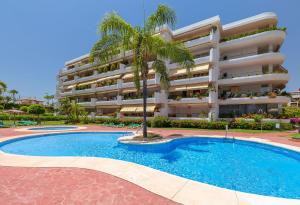 马贝拉Fantastic Apartment Next To Guadalmina Golf Course In Marbella的游泳池前有棕榈树的酒店