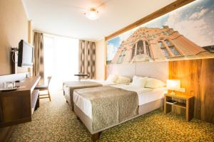 凯奇凯梅特Aranyhomok Business-City-Wellness Hotel的酒店客房设有一张大床和一张书桌。