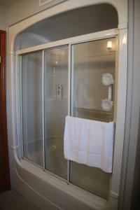 斯特拉福德乡村风情住宿加早餐旅馆的浴室玻璃淋浴间门上挂着毛巾