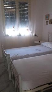 圣凯撒利亚温泉Le Querce Santa Cesarea Terme的卧室设有两张单人床和窗户。