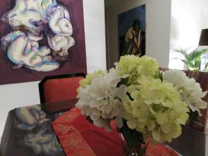 马拉加Apartamento Aurora的坐在桌子上的白花花瓶