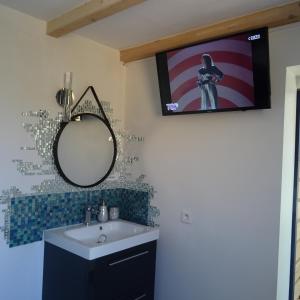 Borgo2 pièces indépendant avec son jardinet privé的一间带水槽的浴室和墙上的电视