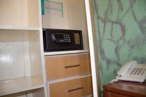 内罗毕白灰酒店的一间配有微波炉的厨房和一部电话