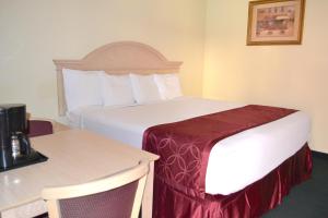 尼亚加拉瀑布尼亚加拉瀑布帕斯波特酒店的酒店客房设有一张大床和一张桌子。