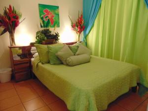 圣何塞卡萨利马住宿加早餐酒店的一间卧室配有一张带绿色窗帘的床