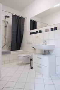 莱比锡Ferienwohnung am Völkerschlachtdenkmal的白色的浴室设有水槽和卫生间。